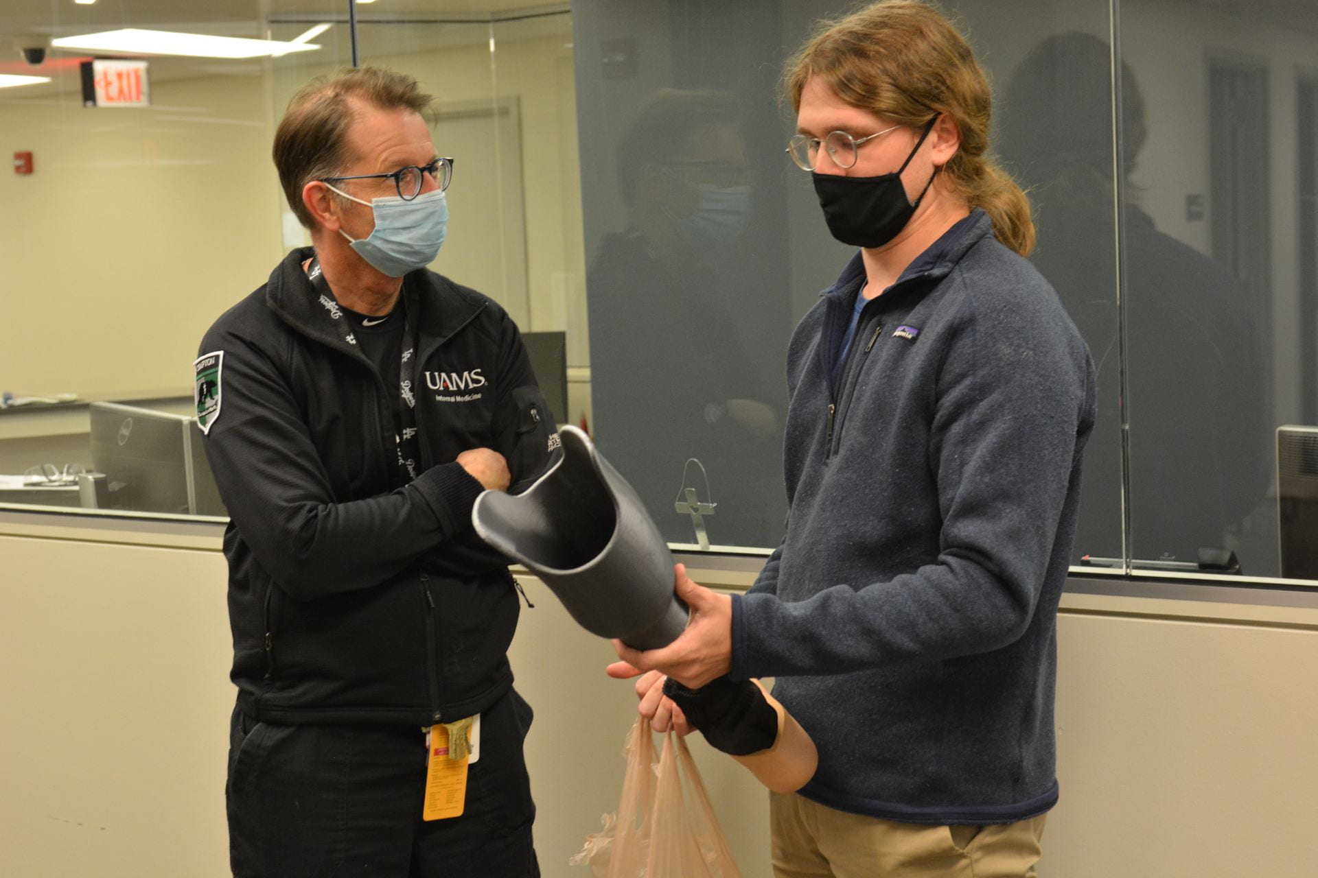 Dr. Tom Schulz (left), director of the UAMS North Street Marshallese Clinic, speaks with U of A student Kyle Potts.